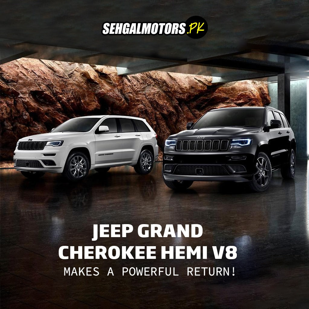 White and black Jeep Grand Cherokee Hemi V8 SUVs in a modern showroom with rock wall backdrop